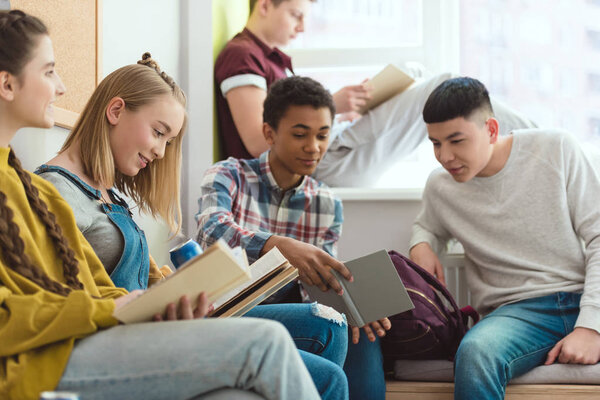 Группа мультикультурных старшеклассников-подростков делает домашнее задание во время школьных каникул
 