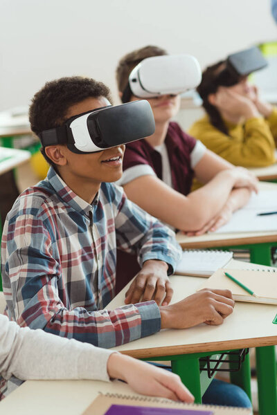 Multiethnic high school students using virtual reality headsets in classroom