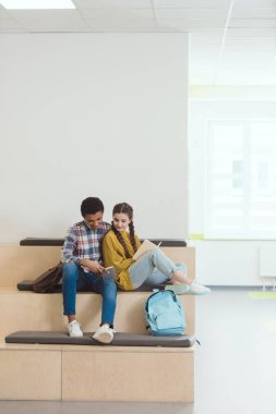 high school students couple doing homework at school corridor together clipart