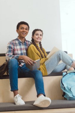 high school students couple sitting together at school corridor clipart