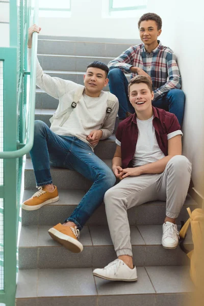 Okulda Merdivenlerde Oturan Kameraya Bakarak Genç Öğrenciler — Stok fotoğraf