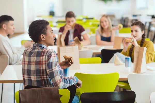 Grupo Estudantes Ensino Médio Conversando Enquanto Almoça Cafetaria Escola — Fotografia de Stock