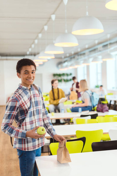 smiling african american schoolboy at school cafeteria
