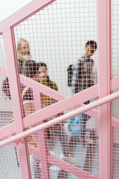 Blick Durch Das Gitter Auf Eine Gruppe Von Gymnasiasten Auf — kostenloses Stockfoto