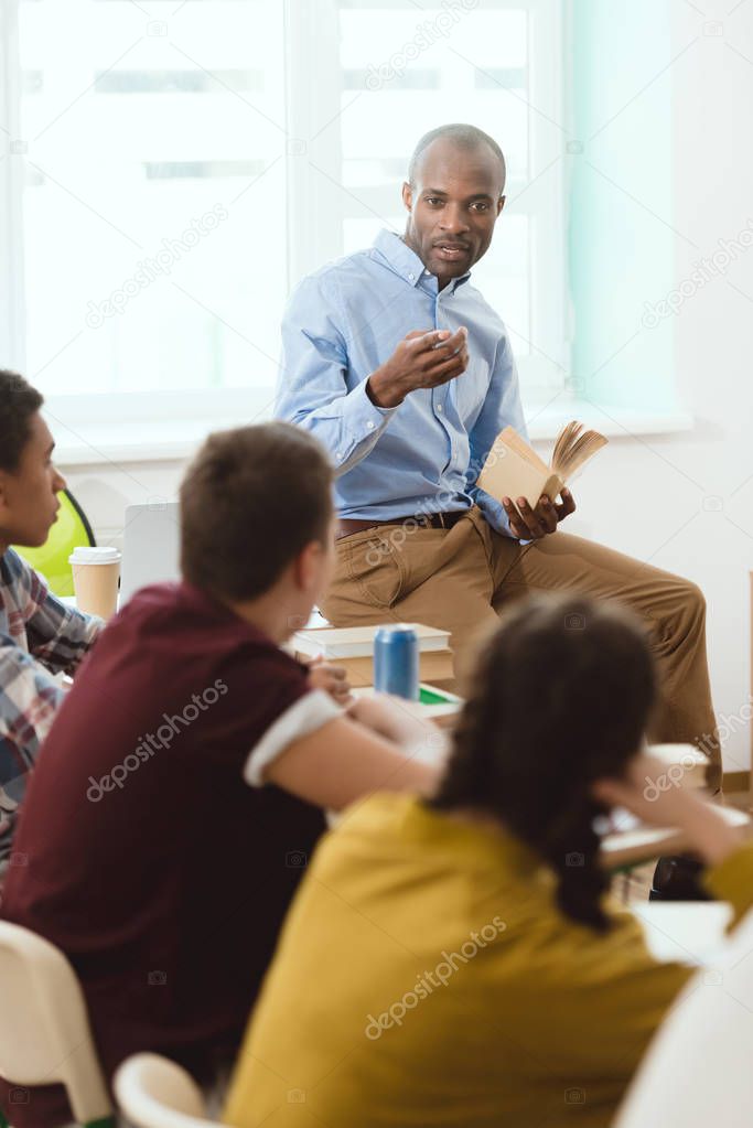 teacher performing lecture for high school students