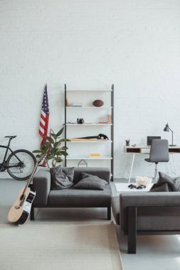 modern oturma odası bisiklet, gitar, Amerikan bayrağı, dizüstü bilgisayar, raflar ve koltuklar ile iç 