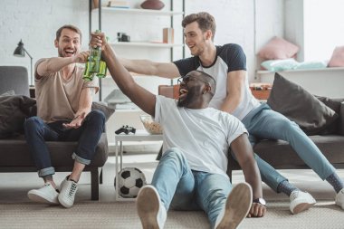 futbol maçı izlerken çok ırklı genç erkekler ve kutluyor ve bira şişesi tungur 