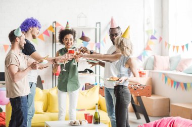 Cheerful diverse people toasting with champagne at birthday party