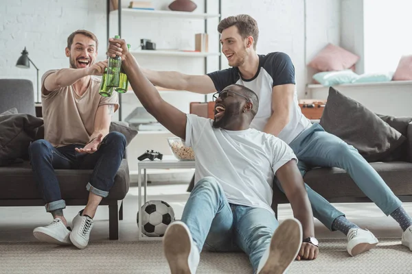 Jovens Multiétnicos Assistindo Jogo Futebol Celebrando Clinking Garrafas Cerveja — Fotografia de Stock