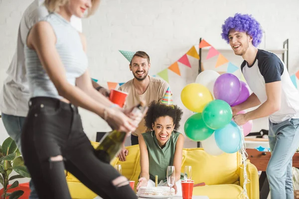 Jóvenes Alegres Mirando Mujer Abriendo Champán Fiesta Cumpleaños — Foto de Stock