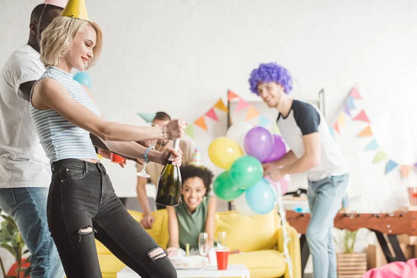 Blonde Woman Opening Champagne Front Partying Friends — Stock Photo, Image