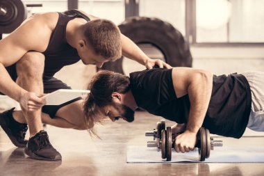 sporcu gönderme yapıyor iterek eğitmen yan görünüm halter salonunda ups