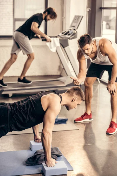 Entrenador Contando Mientras Deportista Haciendo Tablón Bloques Yoga Gimnasio — Foto de Stock