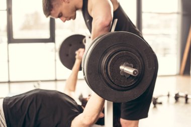 yakışıklı eğitmen sporcu spor salonunda ağır ağırlıklar ile Halter kaldırma Yardım