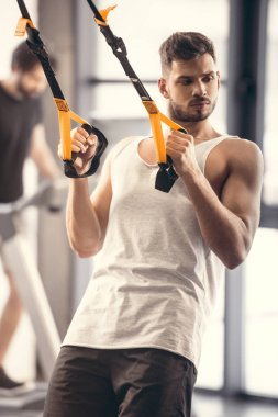 direnç bands ile eğitim ve uzak seyir spor salonunda yakışıklı kaslı genç adam