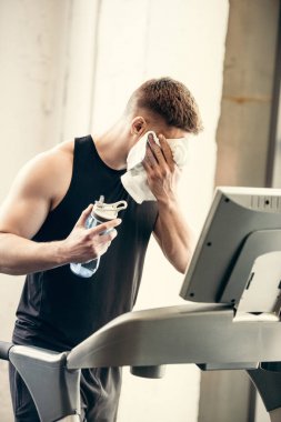 havlu ve şişe su eğitim koşu bandı ile genç sporcu