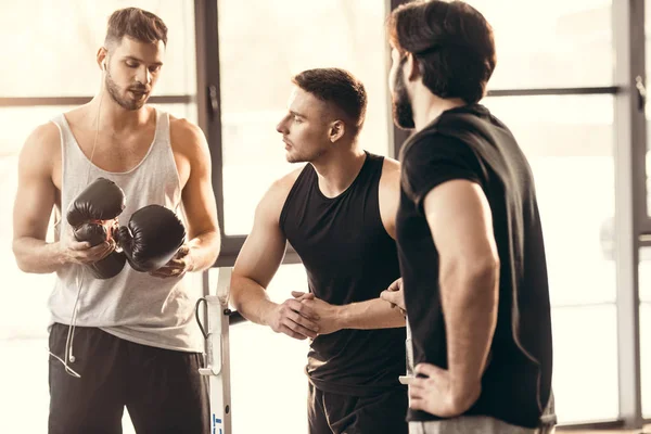 Tres Jóvenes Atléticos Ropa Deportiva Hablando Gimnasio —  Fotos de Stock