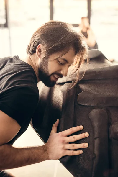 Concentrated Sporty Young Man Lifting Tyre Gym — Free Stock Photo