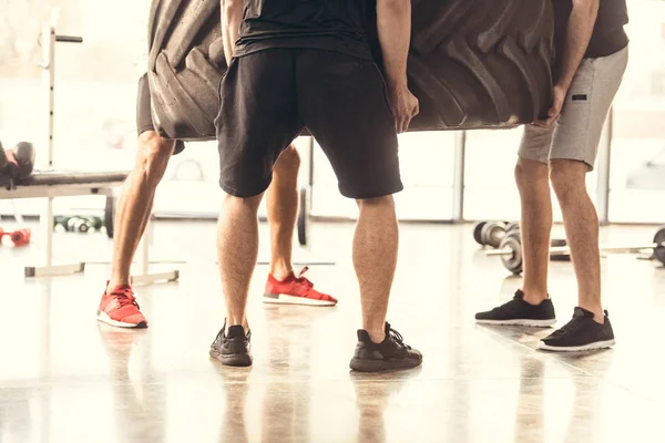 Sección Baja Tres Hombres Atléticos Neumáticos Elevación Ropa Deportiva Gimnasio — Foto de Stock