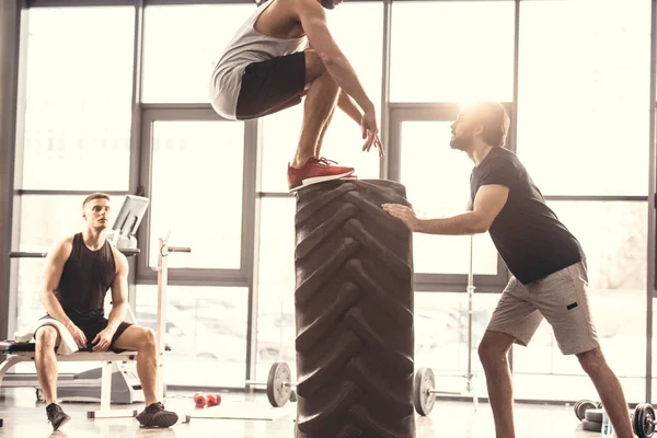 Cropped Shot Sporty Young Men Exercising Tyre Gym — Free Stock Photo