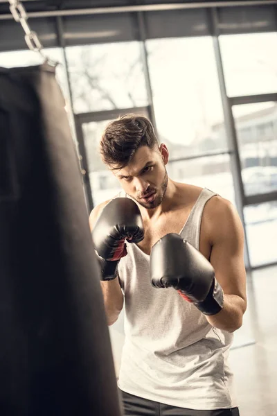 Concentrated Young Sportsman Boxing Gloves Looking Punching Bag Gym — Stock Photo, Image