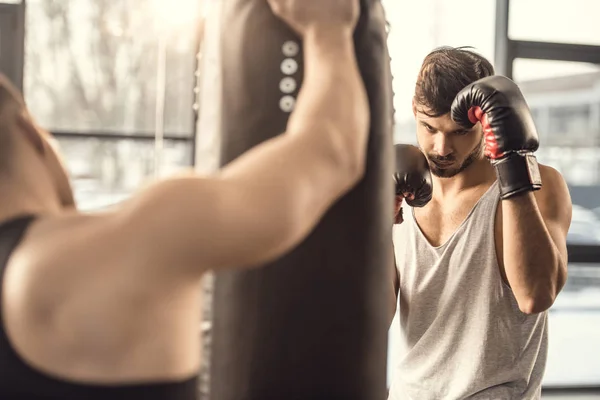 Recortado Tiro Entrenador Sosteniendo Saco Boxeo Mientras Boxeador Entrenamiento Gimnasio — Foto de Stock