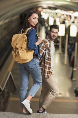 sırt çantaları metro istasyonunda turistlerle şık çift