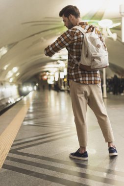 erkek kol saati metro istasyonunda bakarak sırt çantası ile 