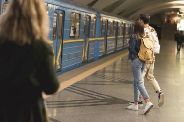 Metro istasyonunda sırt çantalı şık turistlerin arka manzarası