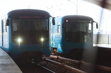 front view of two trains at outdoor subway station  clipart