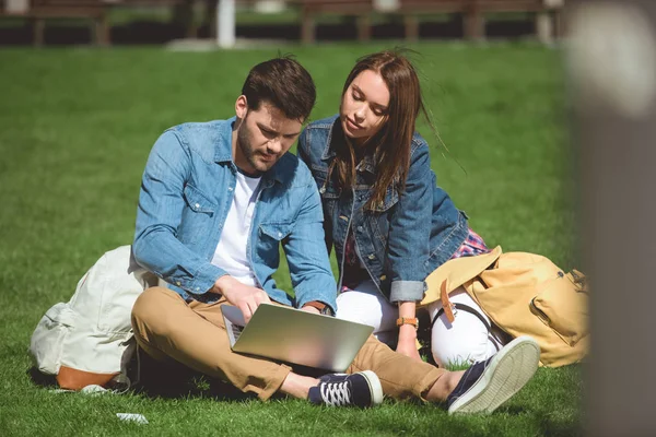 Young Tourists Backpacks Laptop Sitting Grass — Free Stock Photo