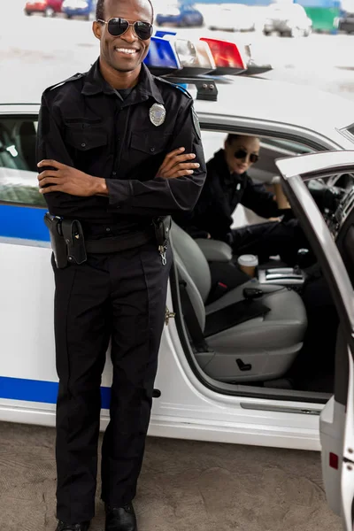 Polis Arabasının Önünde Duran Çapraz Kollu Yakışıklı Genç Polis Memuru — Stok fotoğraf