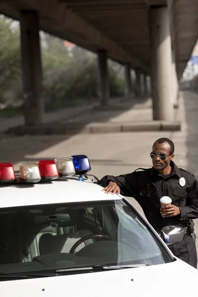 Polizist Mit Coffee Lehnt Sich Auf Der Straße Polizeiauto — Stockfoto