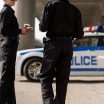 Uśmiechający się funkcjonariusze policji o przerwa na kawę i rozmowy przed samochodem