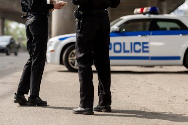 Polis memuru polis arabasının önünde duran kırpılmış atış