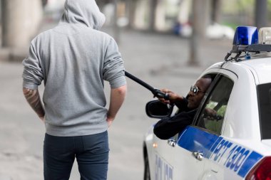 Dikiz Afro-Amerikan polis polis sopası ile kukuletalı adam pencereden dışarı bakarken durdurma