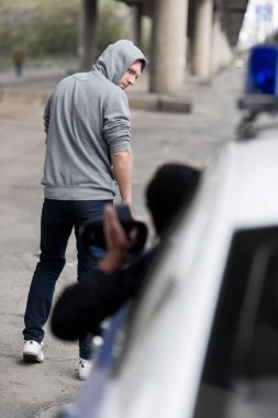 kapüşonlu genç adam çekip sokak pencereden dışarı bakıp polis