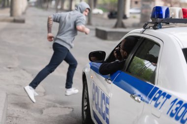 araba hırsızı kovalayan Afro-Amerikan Polis