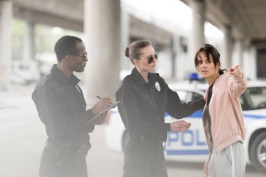 Genç endişeli kadın polis ve polis Pano'da yazma parmak tarafından işaret 