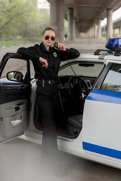 Poliziotta Occhiali Sole Piedi Vicino Alla Macchina Parlando Alla Radio Immagine Stock