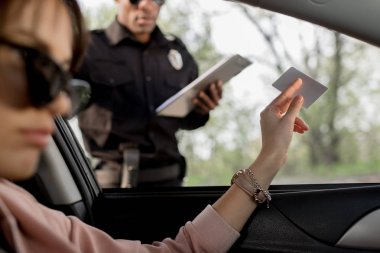 kadın arabada oturan ve polis için şoför ruhsat veren güneş gözlüğü 