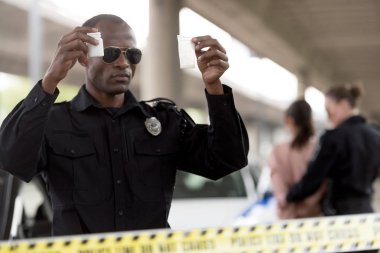 tutan genç Afro-Amerikan polis memuru plastik fermuar uyuşturucu ve hap kavanoz 