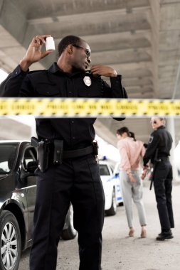 uyuşturucu hap kavanozu holding ve taşınabilir radyo konuşurken Afro-Amerikan Polis 