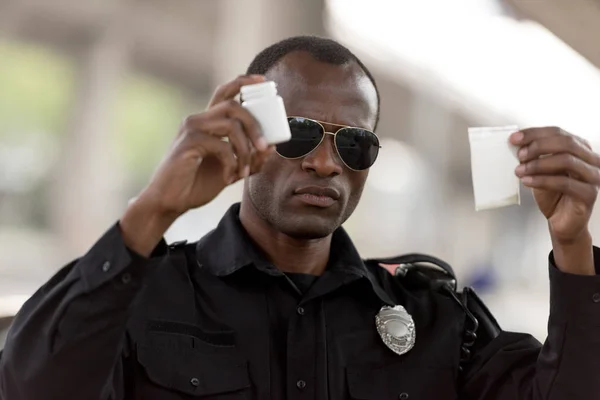 Policial Afro Americano Segurando Drogas Plástico Zíper Pílulas Jar — Fotografia de Stock