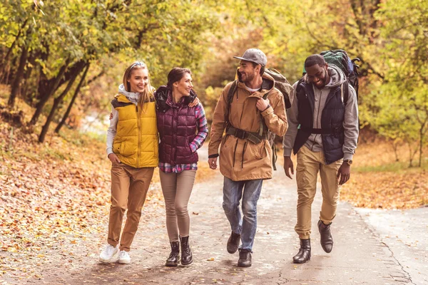 Happy young backpackers in forest — Stock Photo