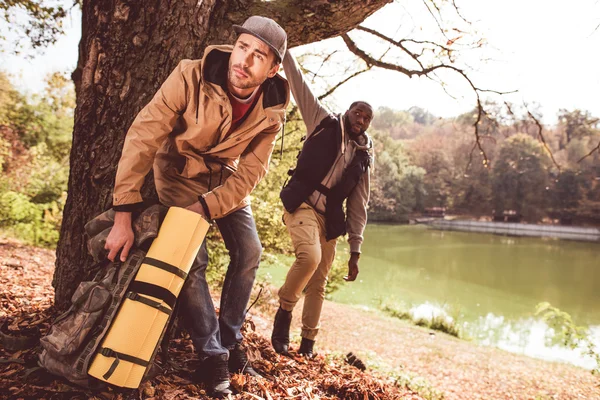 Uomini backpackers in piedi vicino al fiume — Foto stock