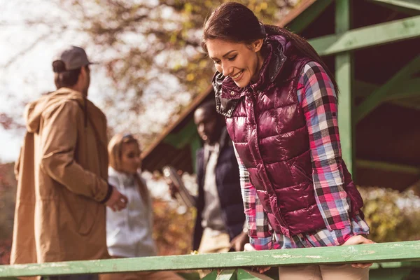 Smiling young woman leaning on railing — Stock Photo