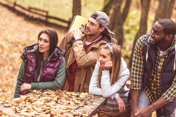 Giovani amici backpackers seduti a tavola — Foto stock