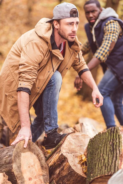 Junge Männer in der Nähe trockener Baumstümpfe im Wald — Stockfoto