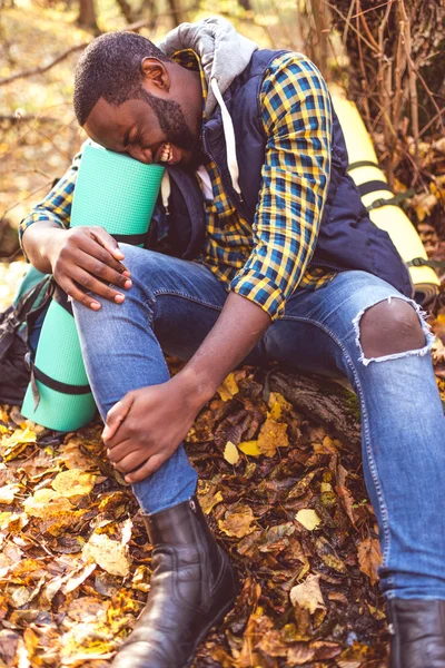 Hombre con pierna lesionada en el bosque - foto de stock